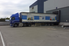 Articulated truck on loading bay with curtainsider trailer