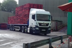 MAN tractor unit with flatbed trailer loaded with pallets