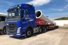 North West logistics Volvo with low loader trailer loaded with piping